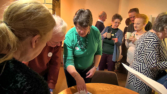 A group of people in discussion by a table