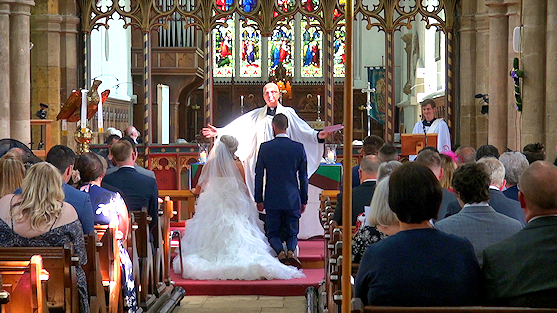 A couple with the vicar, about to exchange vows