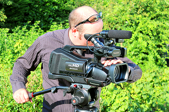 A Lundscapes cameraman filming with shrubbery behind