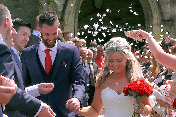 Couple just married with guests throwing confetti